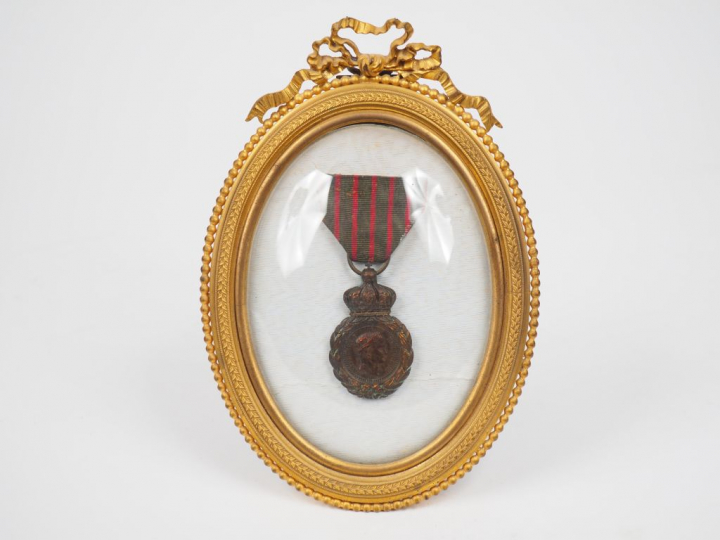 Dans un cadre médaillon de style Louis XVI en bronze doré, médaille de