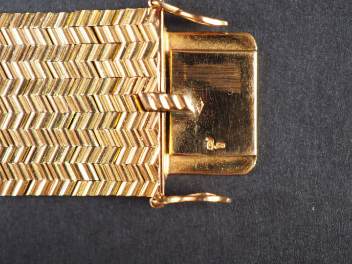 Bracelet manchette en or jaune, maille plate, à décor de motifs géomét