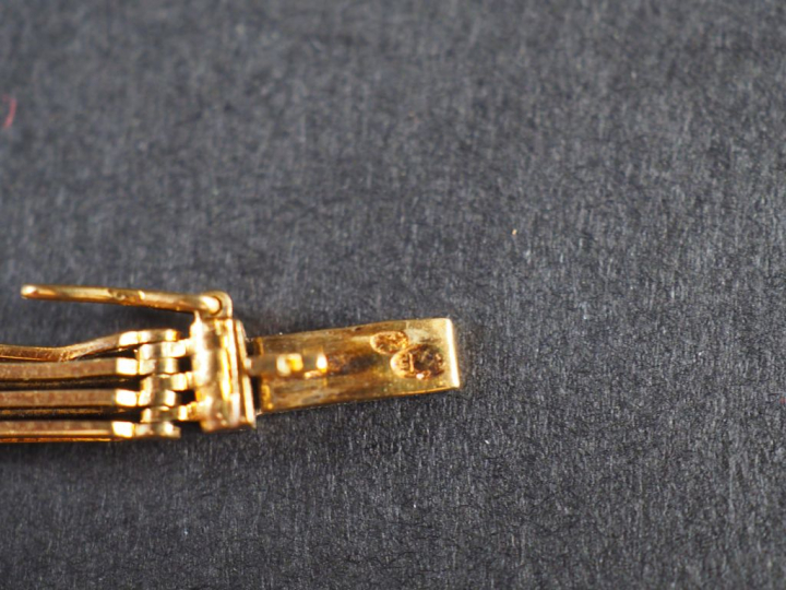 Bracelet articulé en or jaune, composé de maillons rectangulaires.  Lo