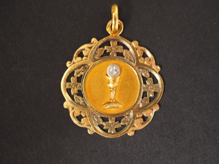 Médaille de baptême en or jaune, à décor de calice et de rinceaux. Poi