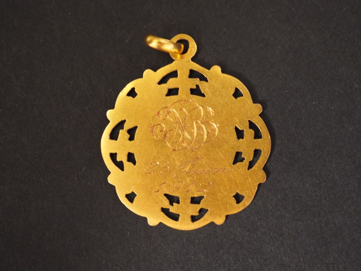 Médaille de baptême en or jaune, à décor de calice et de rinceaux. Poi