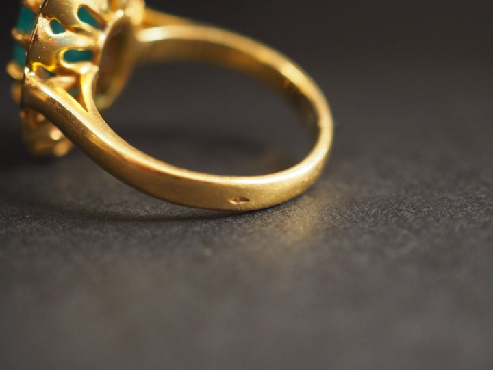 Bague marguerite en or jaune, sertie en son centre d'une émeraude ento