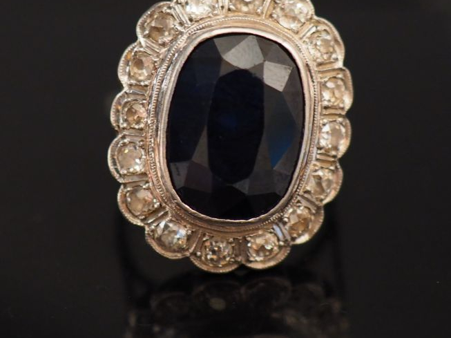 Bague marguerite en or blanc, sertie en son centre d'un saphir entouré