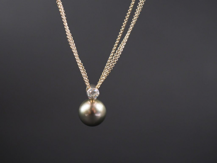 Pendentif en or blanc, à décor de perle grise surmontée d'un petit dia