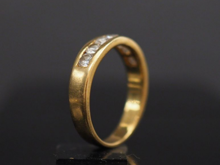 Demi alliance américaine en or jaune, sertie de sept petits diamants. 