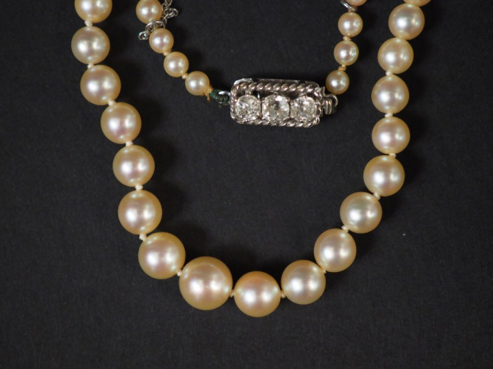 Collier de perles de culture disposées en chute.  Joli fermoir en or b