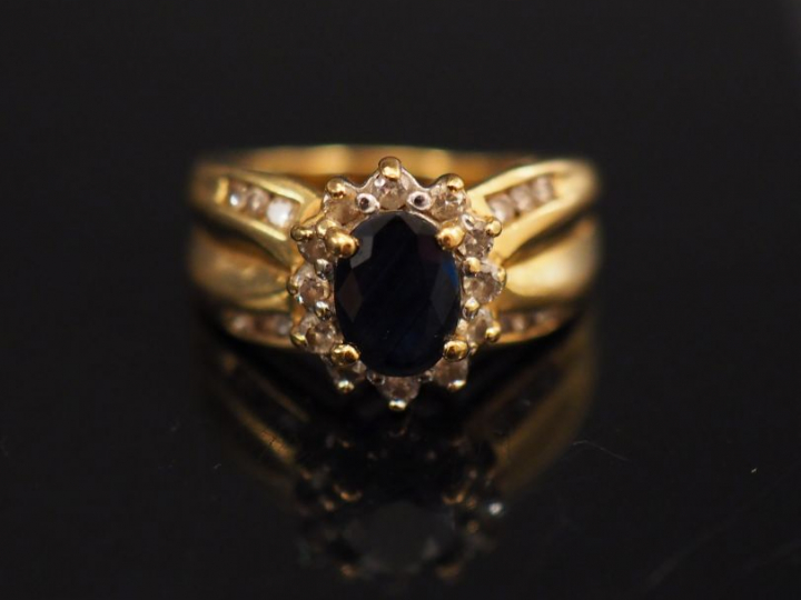 Bague en or jaune, sertie en son centre d'un saphir entouré de petits 
