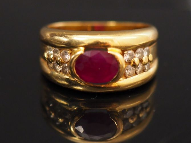 Bague jonc en or jaune, sertie en son centre d'un rubis épaulé de peti