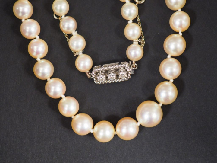 Collier de perles de culture.  Joli fermoir en or blanc, serti de troi