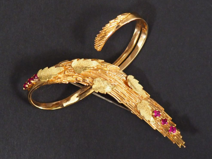 Broche en or jaune en forme de motif stylisé, à décor de feuilles et d