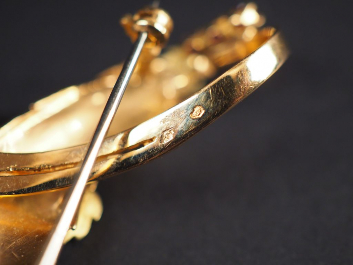 Broche en or jaune en forme de motif stylisé, à décor de feuilles et d