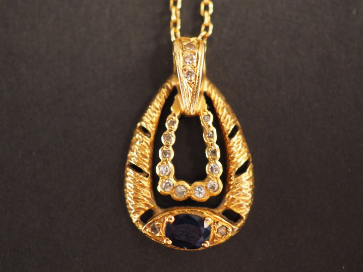 Pendentif et sa chaine en or jaune. Le pendentif à décor de petits dia