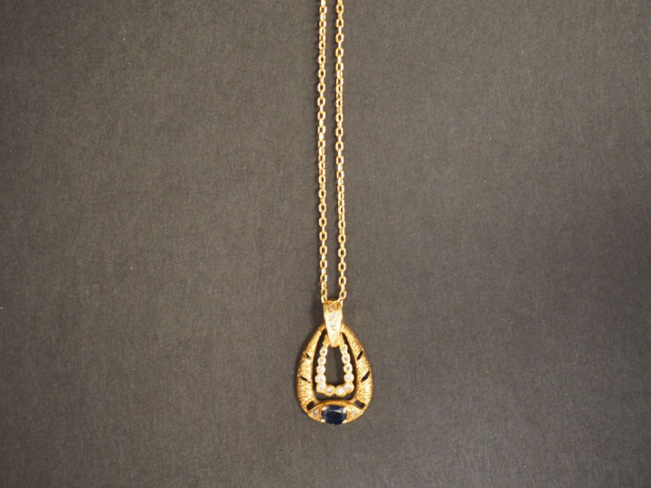 Pendentif et sa chaine en or jaune. Le pendentif à décor de petits dia