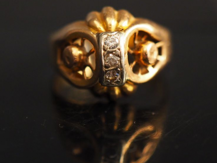 Bague en or jaune, ornée en son centre d'une ligne de trois petits dia