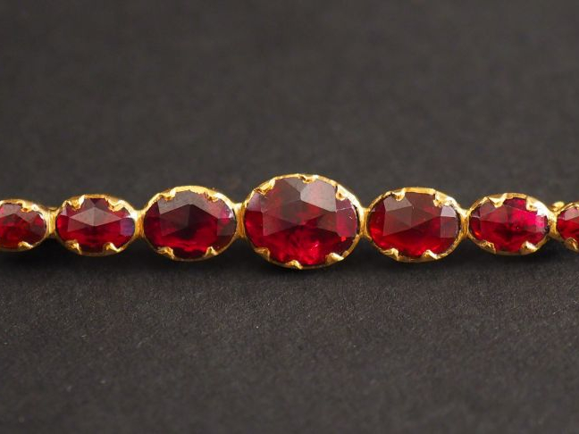 Broche barrette en or jaune et grenats en serti clos.  Long. 6 cm Poid