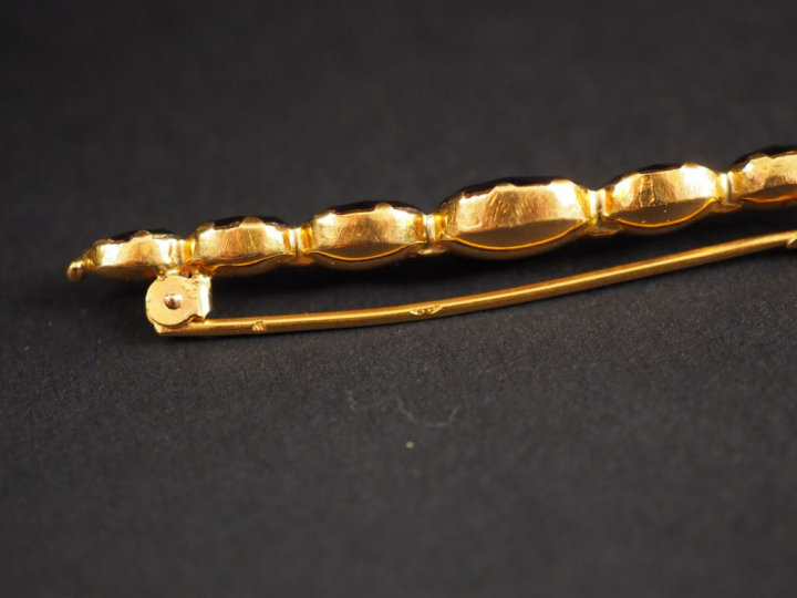 Broche barrette en or jaune et grenats en serti clos.  Long. 6 cm Poid