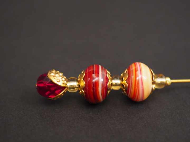 Epingle à cravate en métal doré et pierres dures.