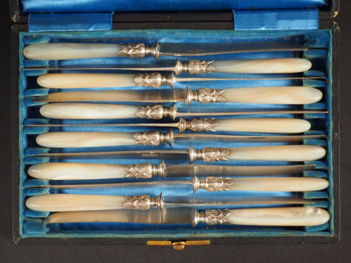 Suite de douze couteaux à dessert, manches en nacre. Dans leur coffret