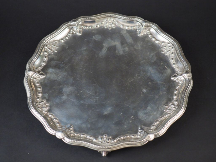 Plat rond en argent anglais, à décor de guirlande de feuillage, reposa