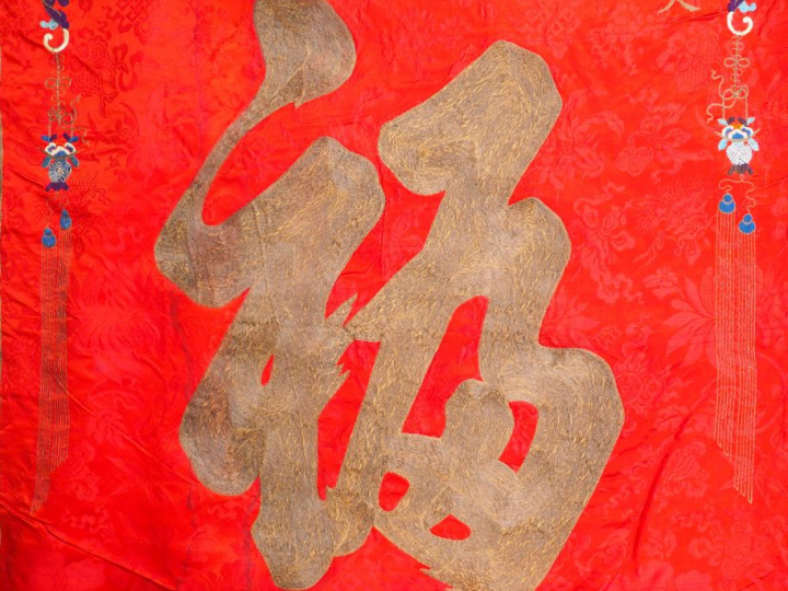 Grand panneau en soie rouge brodé aux fils polychromes et anciennement