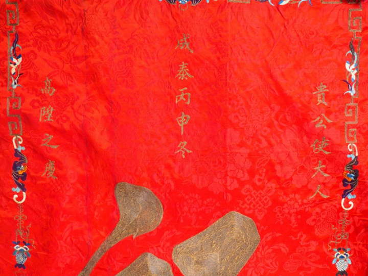 Grand panneau en soie rouge brodé aux fils polychromes et anciennement