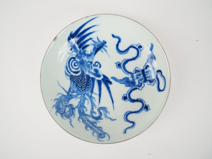 Petite assiette en porcelaine bleu blanc. Le pourtour cerclé de métal.