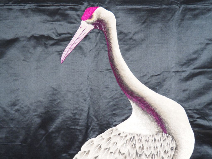 Grand panneau en soie noire brodée d’un couple de grues en camaïeu de 