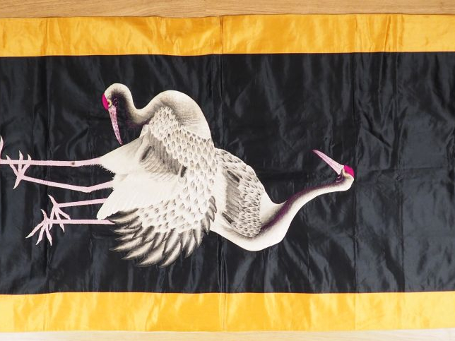 Grand panneau en soie noire brodée d’un couple de grues en camaïeu de 