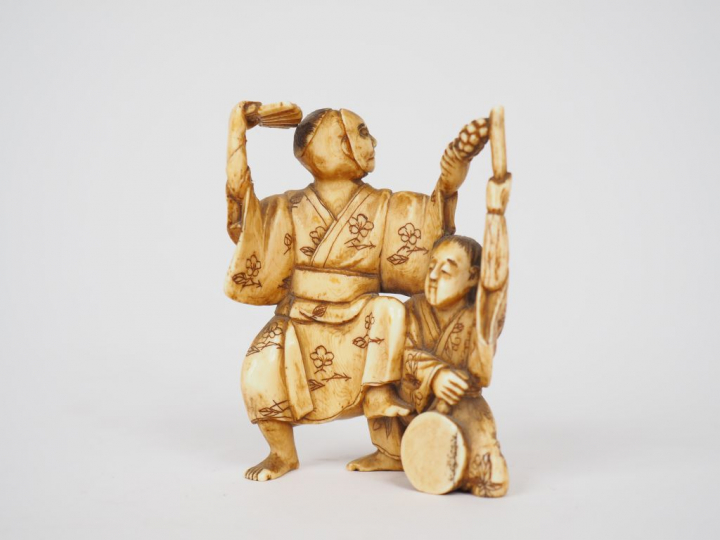 Petit okimono en ivoire représentant un acteur de théâtre accompagné d