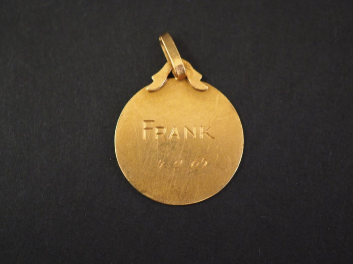 Médaille religieuse en or jaune, figurant un angelot. Diam. 1,9 cm Poi