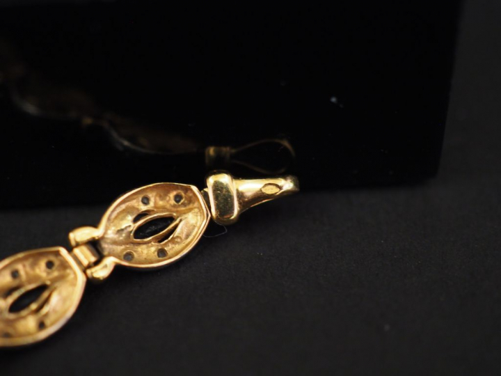 Bracelet articulé deux tons d'or composé de médaillons sertis de saphi