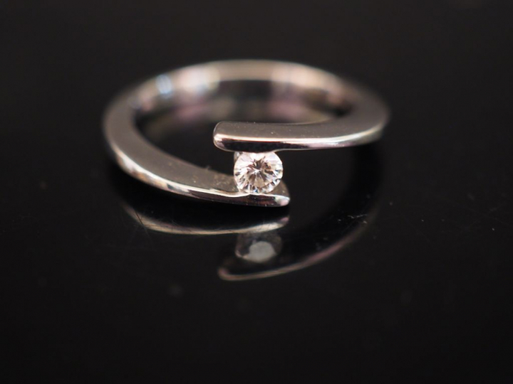 Bague en or blanc de forme stylisée, sertie d'un petit diamant de 0,13
