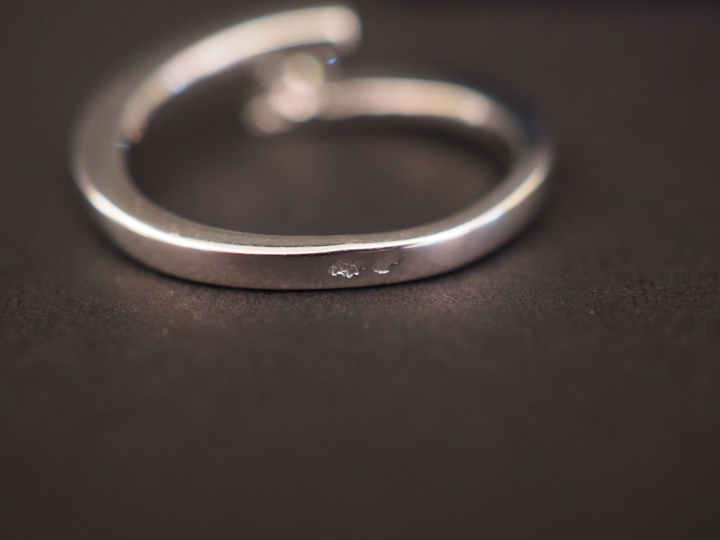 Bague en or blanc de forme stylisée, sertie d'un petit diamant de 0,13