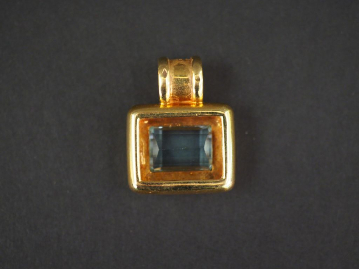 Pendentif en or jaune, serti en son centre d'une aigue marine. La béli