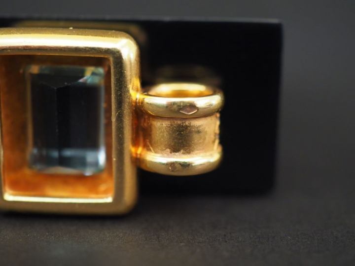 Pendentif en or jaune, serti en son centre d'une aigue marine. La béli