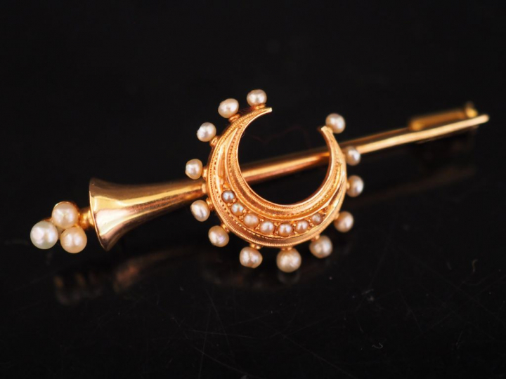 Broche en or jaune et perles, à décor de croissant de lune.  Long. 4,8