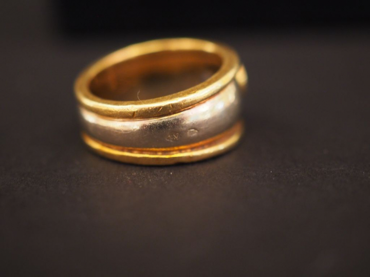 Bague deux tons d'or, ornée d'une pierre bleue en serti clos.  TDD. 45