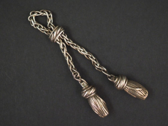 Vente aux enchères HERMES Porte clé en argent , à décor de pompons. Signé. Poids. 19,99 g