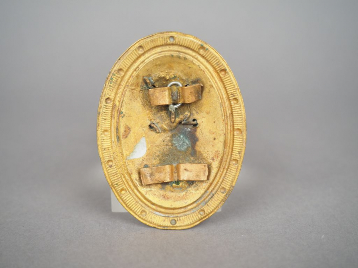 Rosace de harnachement de cavalerie, écu ovale à bord ourlé et perlé, 