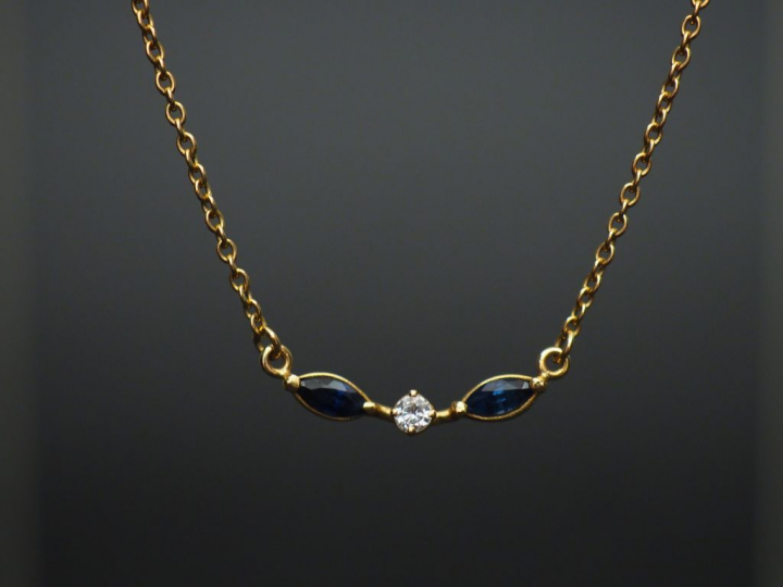 Collier en or, brillant entouré de deux saphirs. Poids : 3,06 g