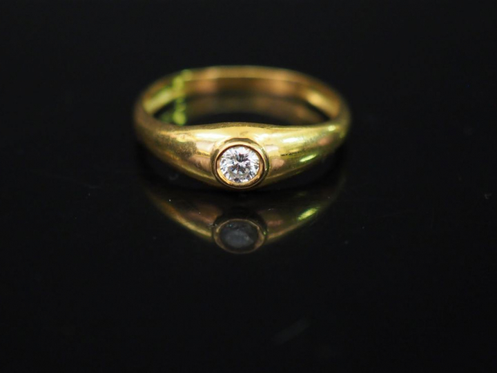 Bague jonc en or jaune, sertie en son centre d'un petit diamant de 0,0