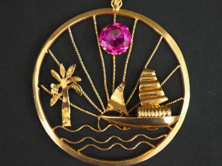 Pendentif circulaire en or jaune, à décor ajouré et en relief d'un voi