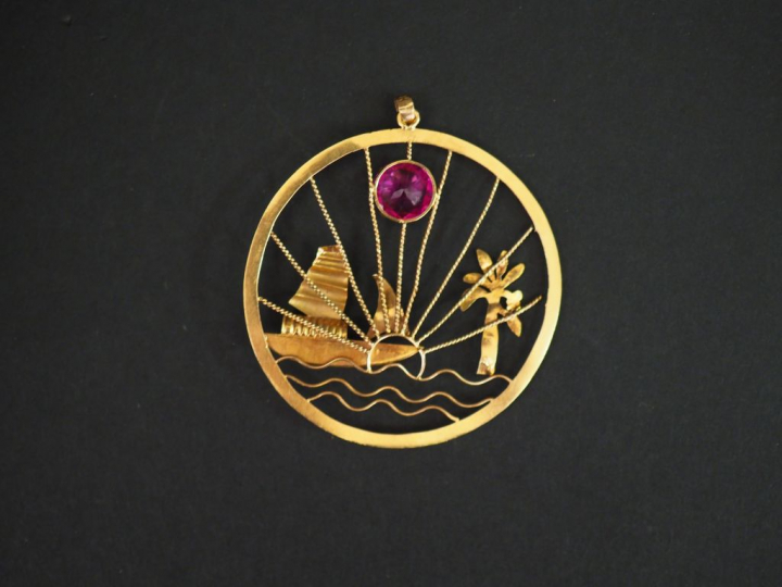 Pendentif circulaire en or jaune, à décor ajouré et en relief d'un voi