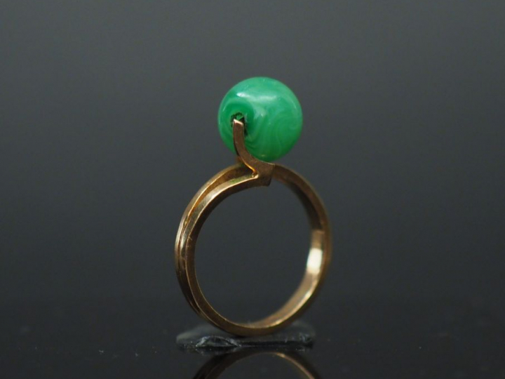 Bague en or jaune, ornée d'une pierre verte en forme de boule. TDD. 49