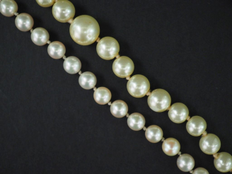 Vente aux enchères Deux différents colliers de perles. Fermoirs en métal. (un accidenté)