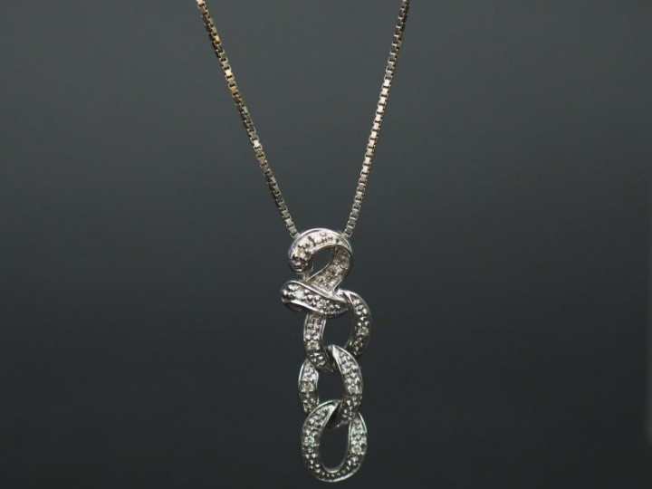 Pendentif et sa chaine en or blanc, serti de petits diamants.  Poids t