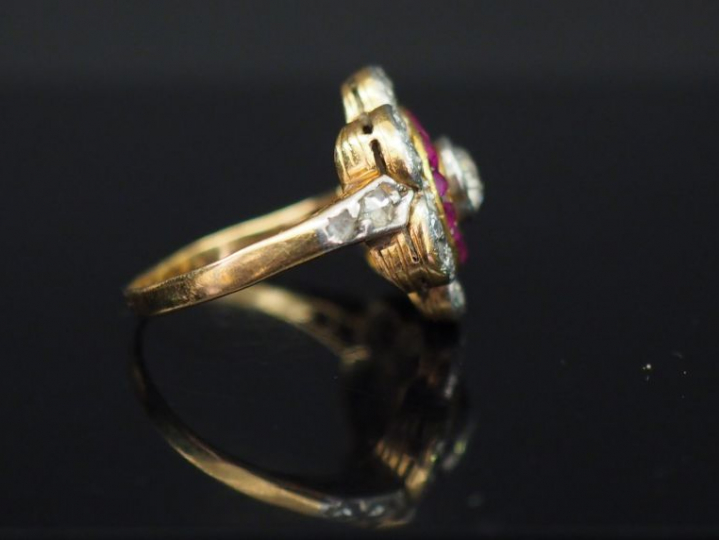 Bague marguerite en or jaune, diamant entouré de rubis calibrés et de 