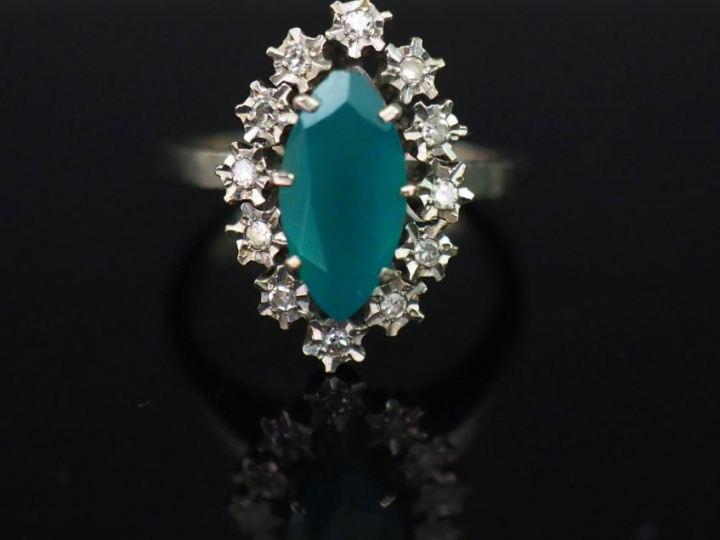 Bague marguerite, pierre verte, entourée de pierres à l'imitation du d