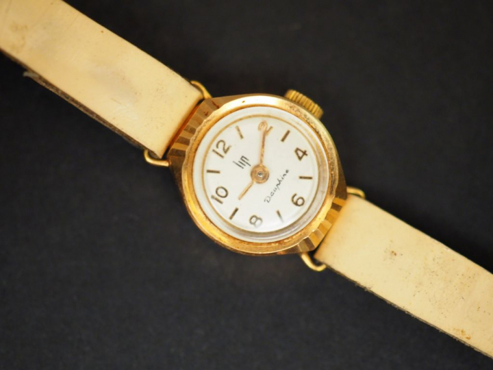 LIP. Montre de dame, boitier or, bracelet cuir.