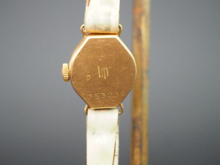 LIP. Montre de dame, boitier or, bracelet cuir.